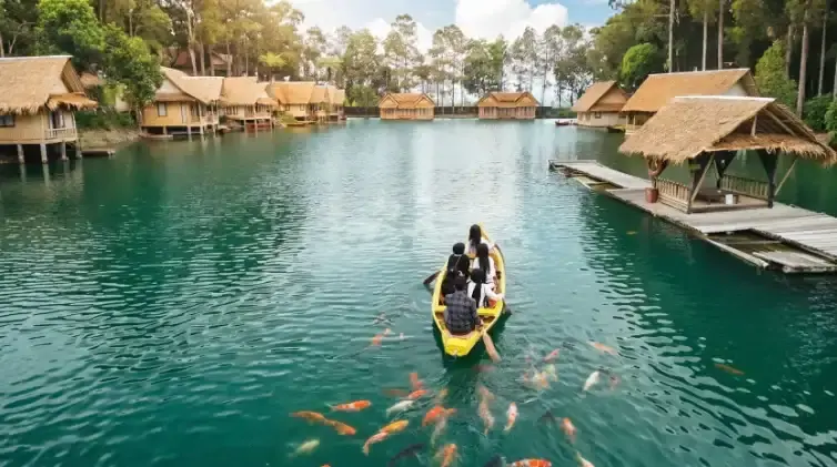 Perahu kecil di danau Kampung Sampireun dengan ikan koi
